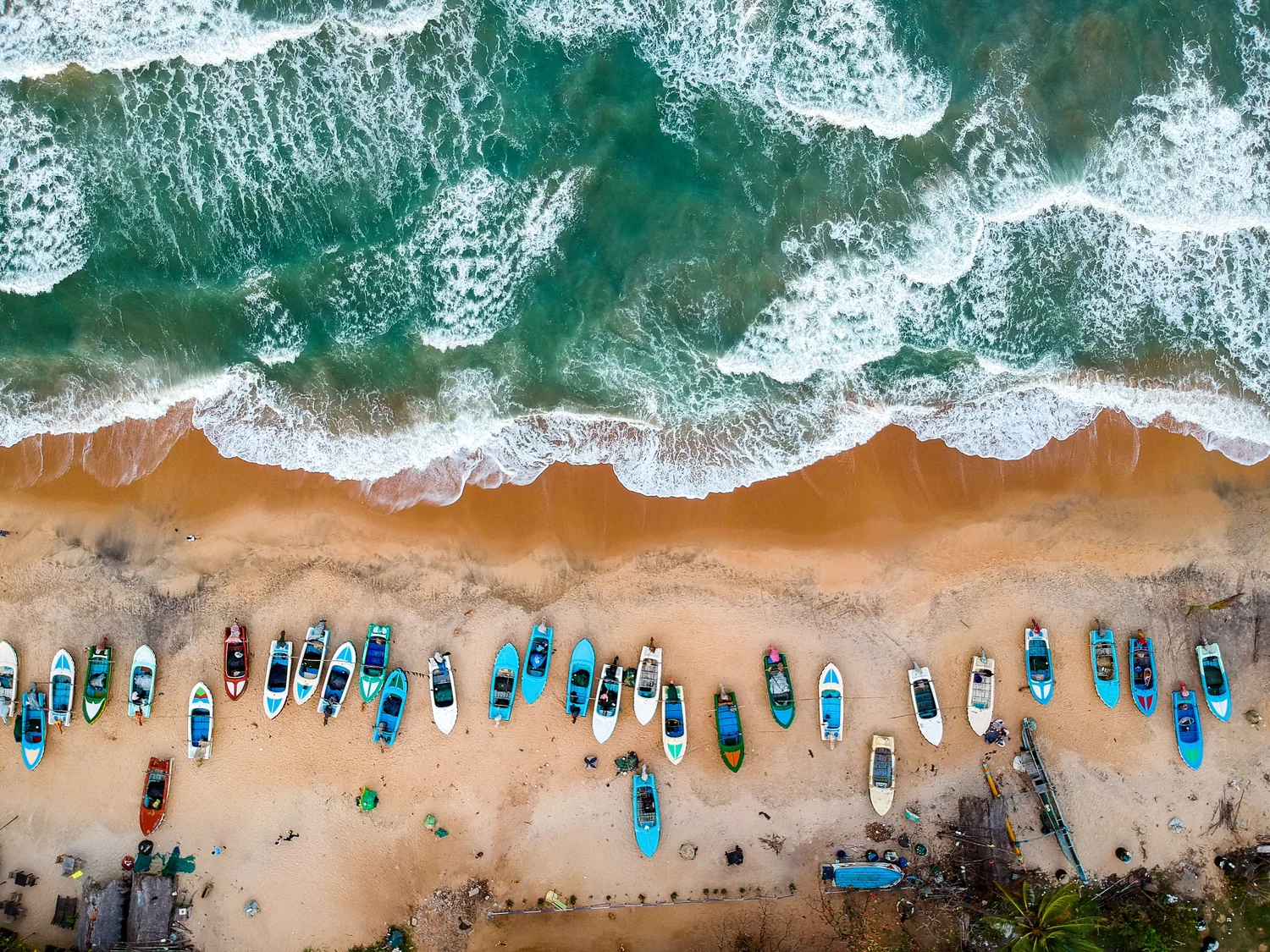 Turquoise Indian Ocean waves washing onto a golden Sri Lankan beach