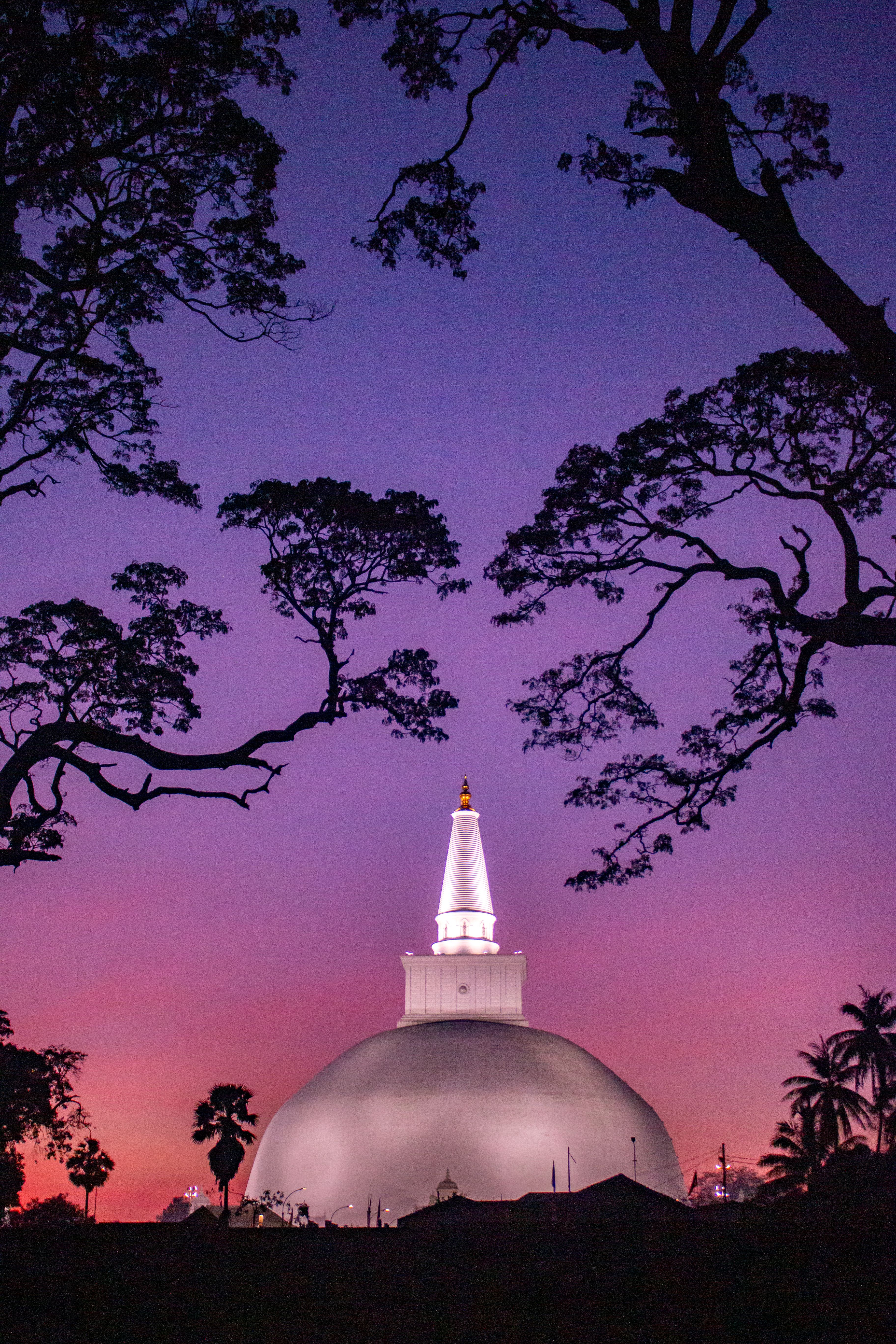 Illuminated Buddhist stupa at twilight in Sri Lanka