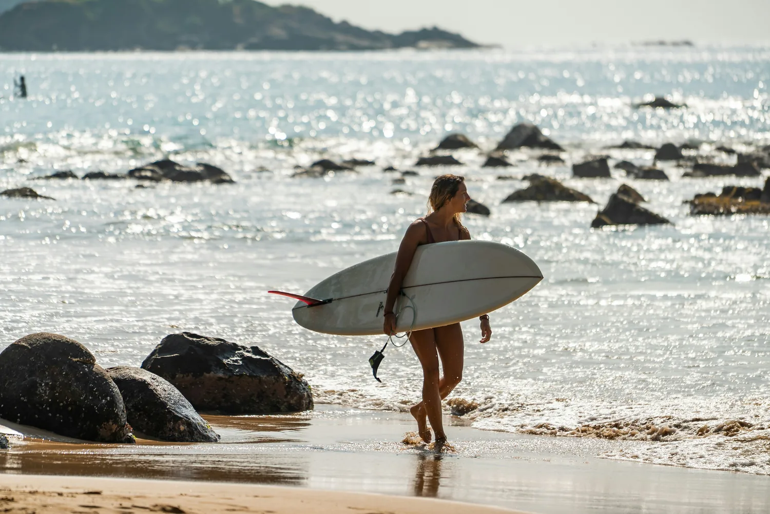 Surfer walking into the sea on Sri Lanka's coast